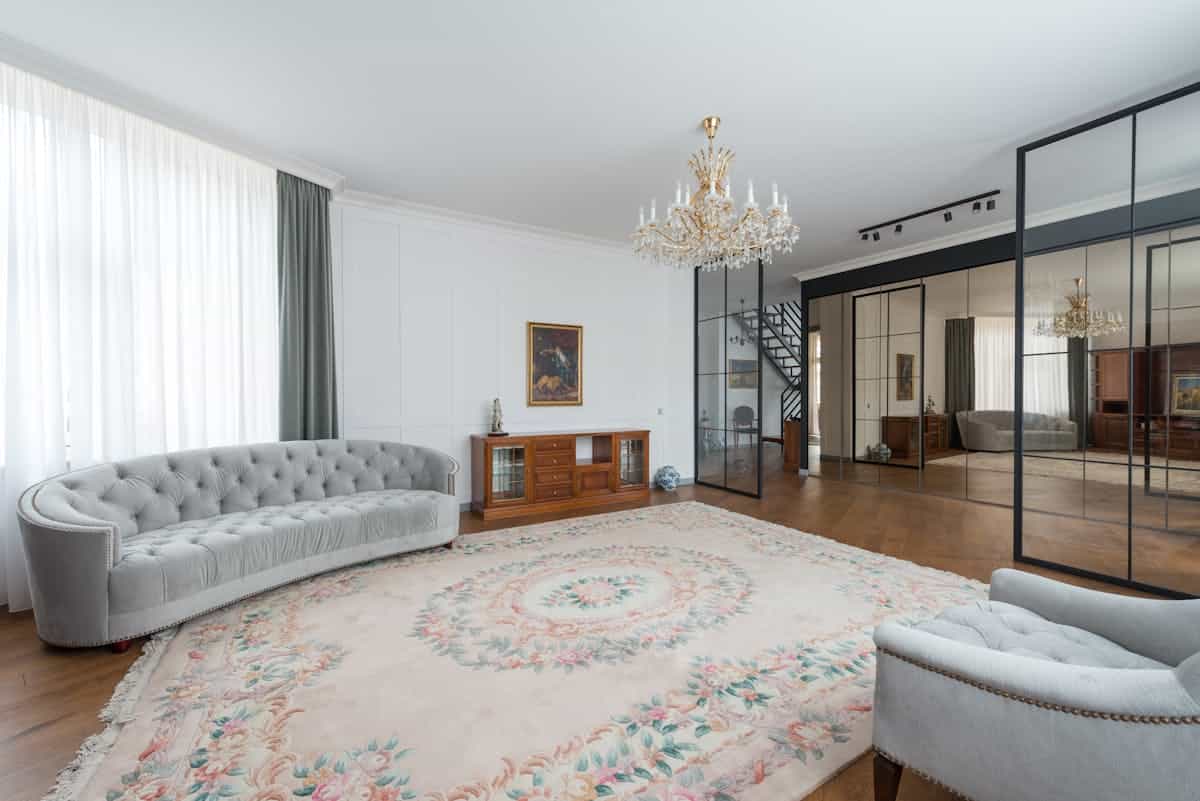 Modern spacious living room with a gray sofa and a big mirror, illustrating extra large mirror sizing