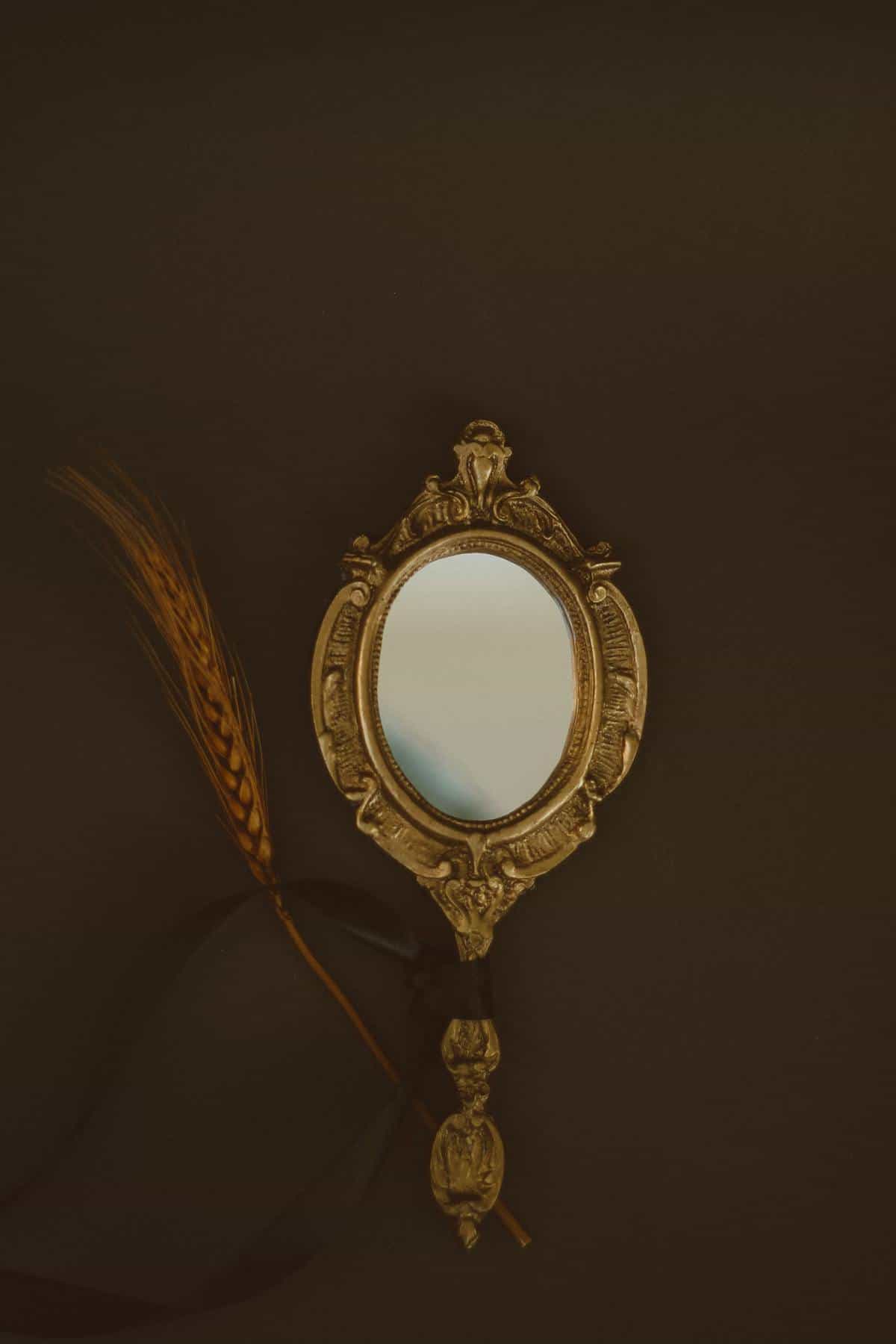 Mysterious hand reaching toward misty mirror surface with dramatic shadows