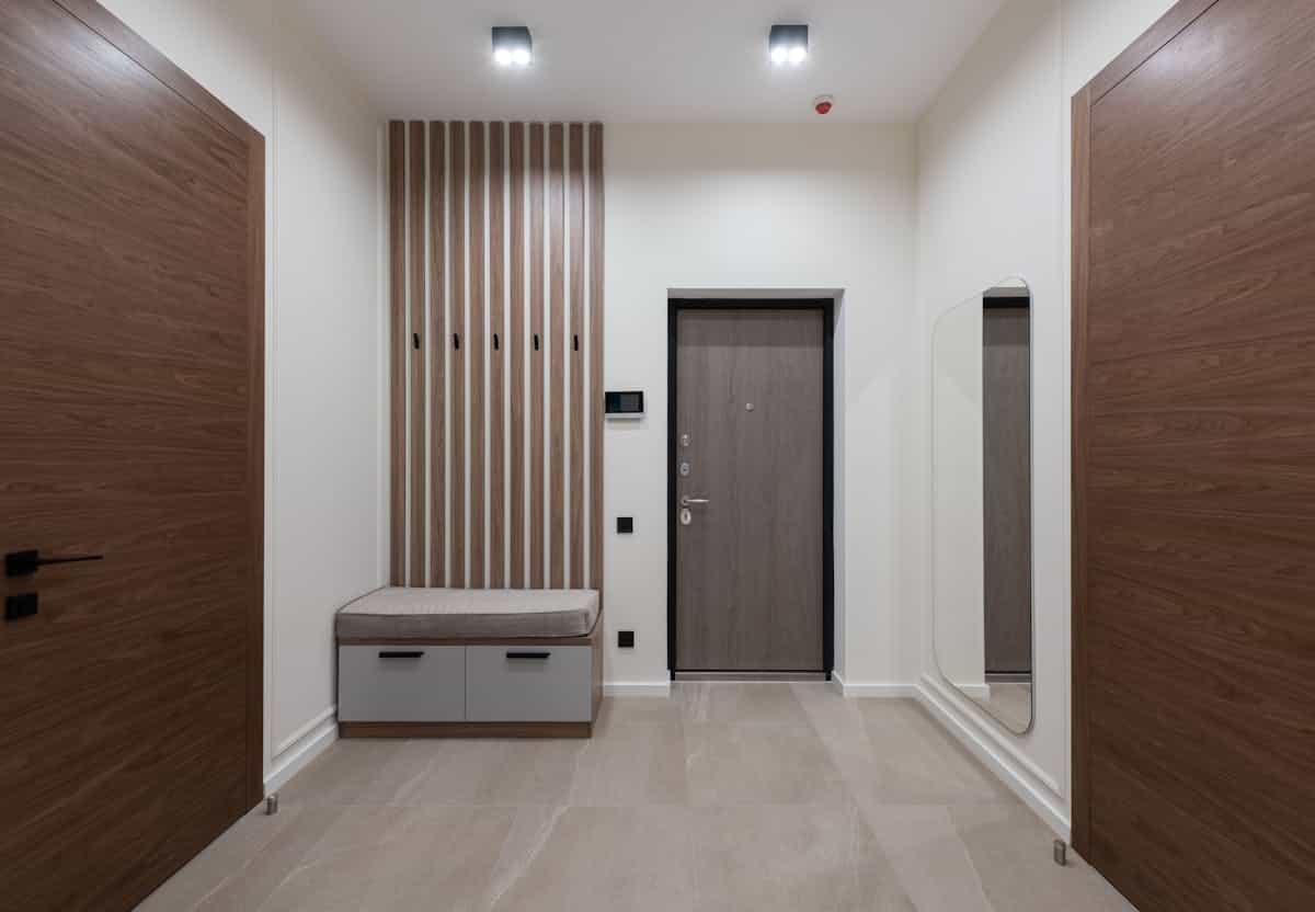 Spacious hallway with a large mirror illustrating how to size an entryway mirror Spacious modern hallway with a large mirror showing how to size an entryway wall mirror