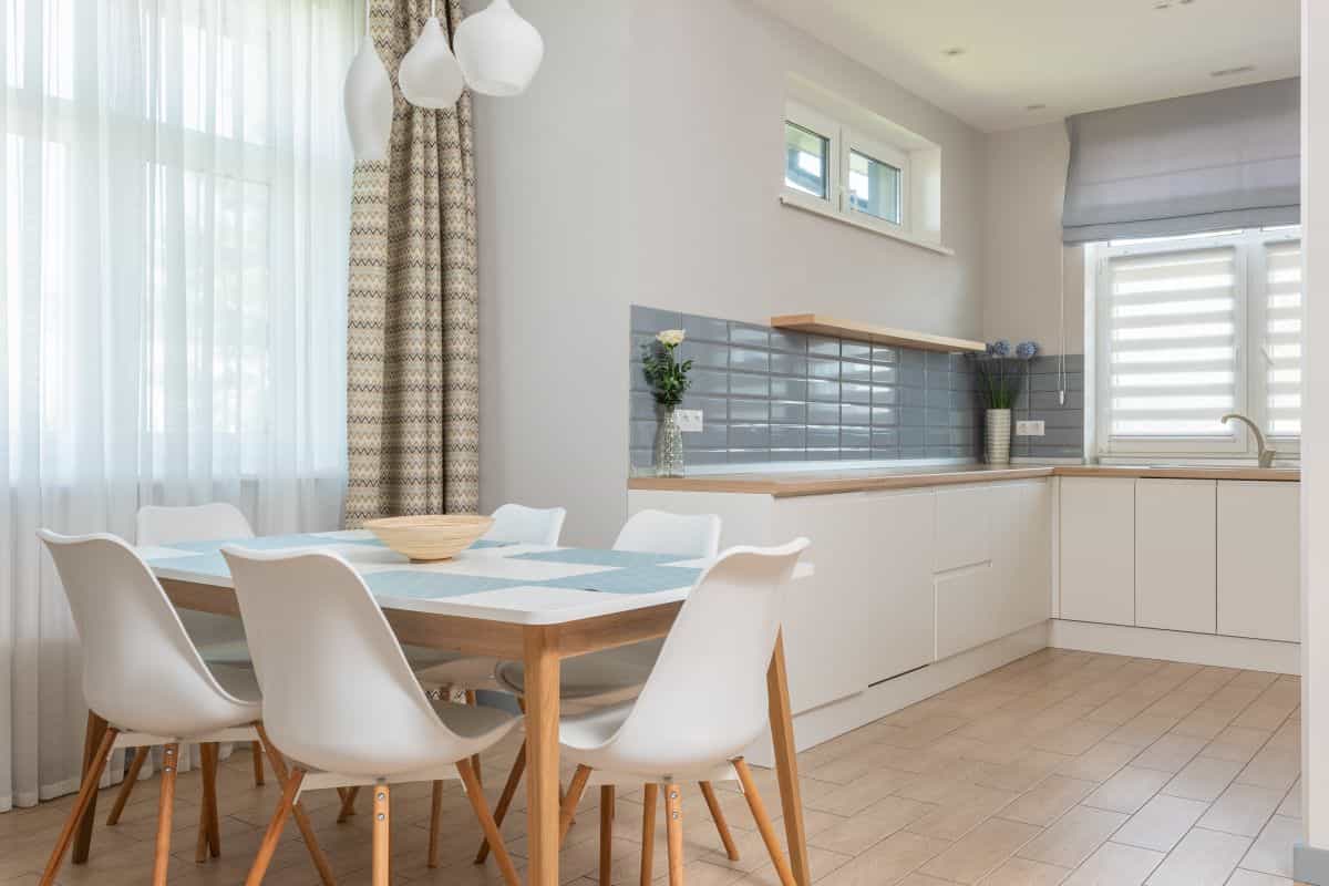 Clean modern kitchen illustrating care and installation of metal wall art Contemporary minimalist kitchen in natural materials, illustrating caring for metal wall art in a kitchen