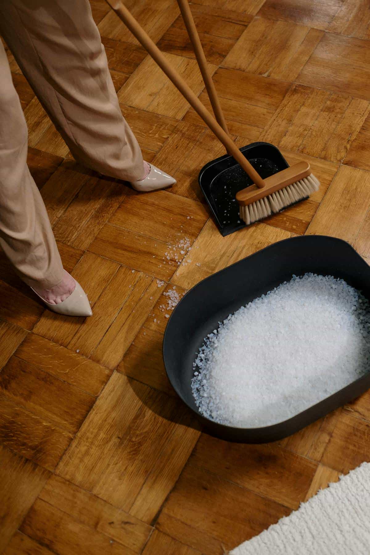 Sweeping floor with broom and dustpan metaphor for emotional cleanup and renewal after dreams Woman sweeping floor with broom onto dustpan metaphor for cleaning up after emotional rupture and renewal