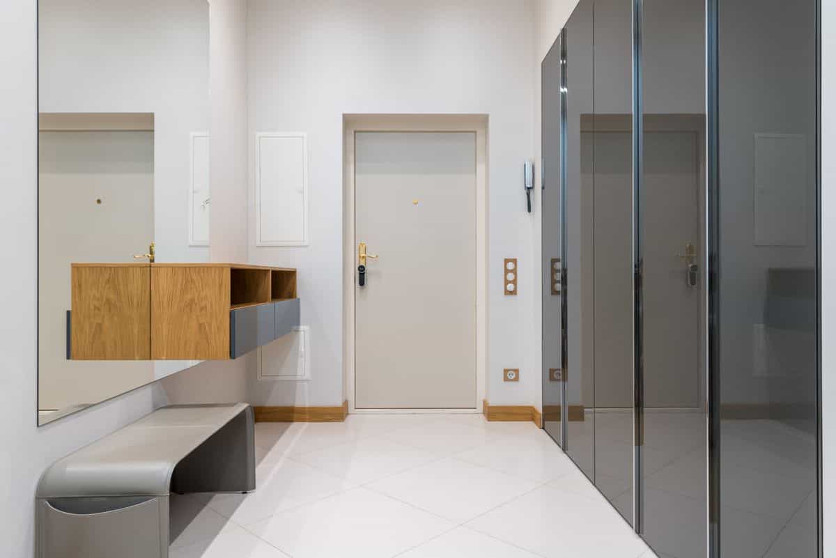 Entryway bench with a shelf and a mirror above it, illustrating a functional and stylish entryway bench with mirror combo.