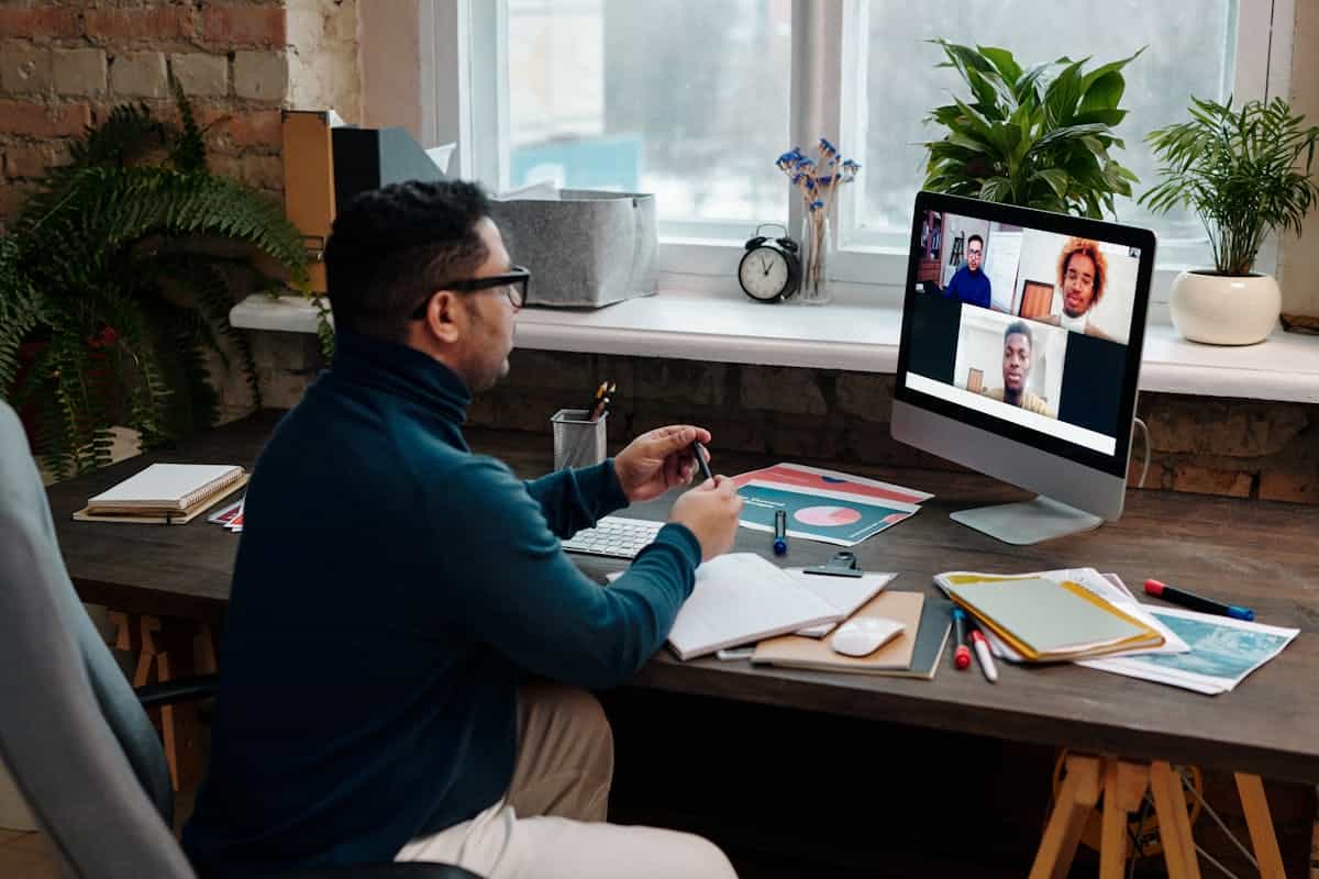 Home office video call illustrating a calm, considered backdrop in a feng shui home office Person on a video call in a home office with greenery behind them, illustrating a feng shui video call backdrop