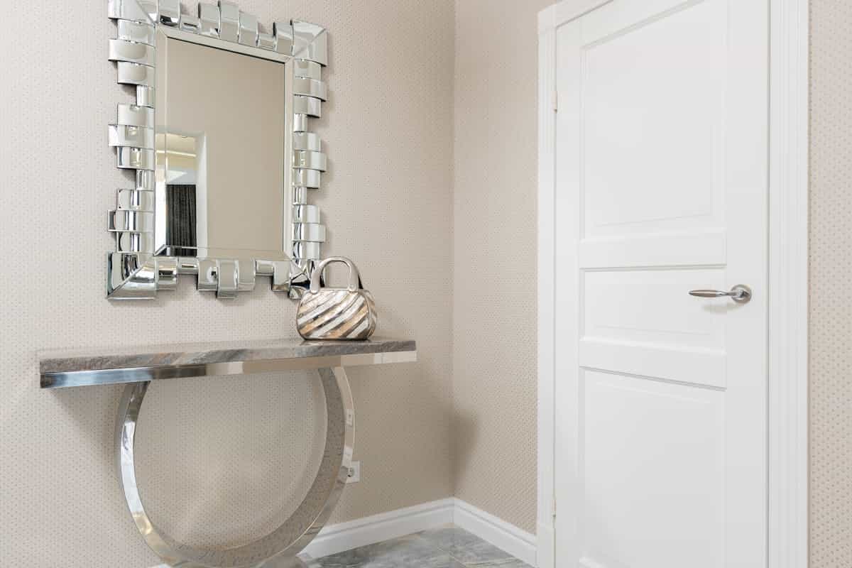 Entryway console table with a decorative mirror above it, illustrating entryway mirror ideas.
