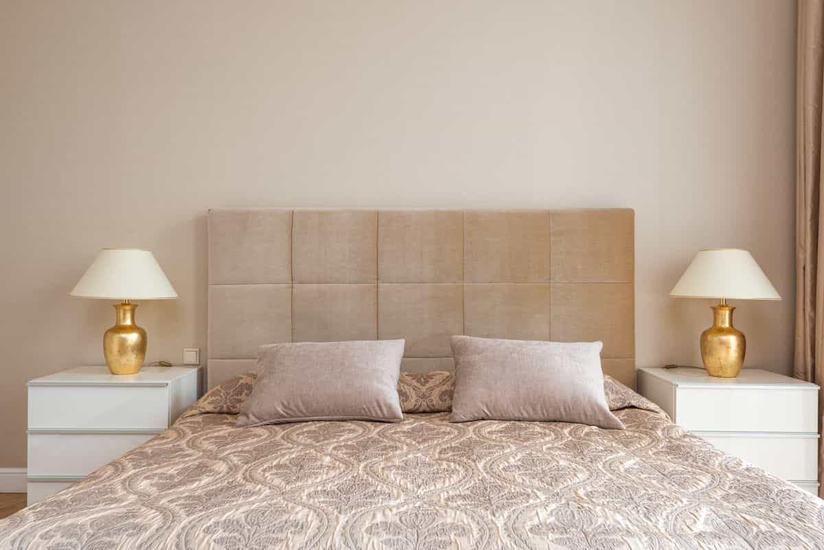 Bedroom with a soft headboard and a matching lamp and nightstand on each side, illustrating feng shui symmetry