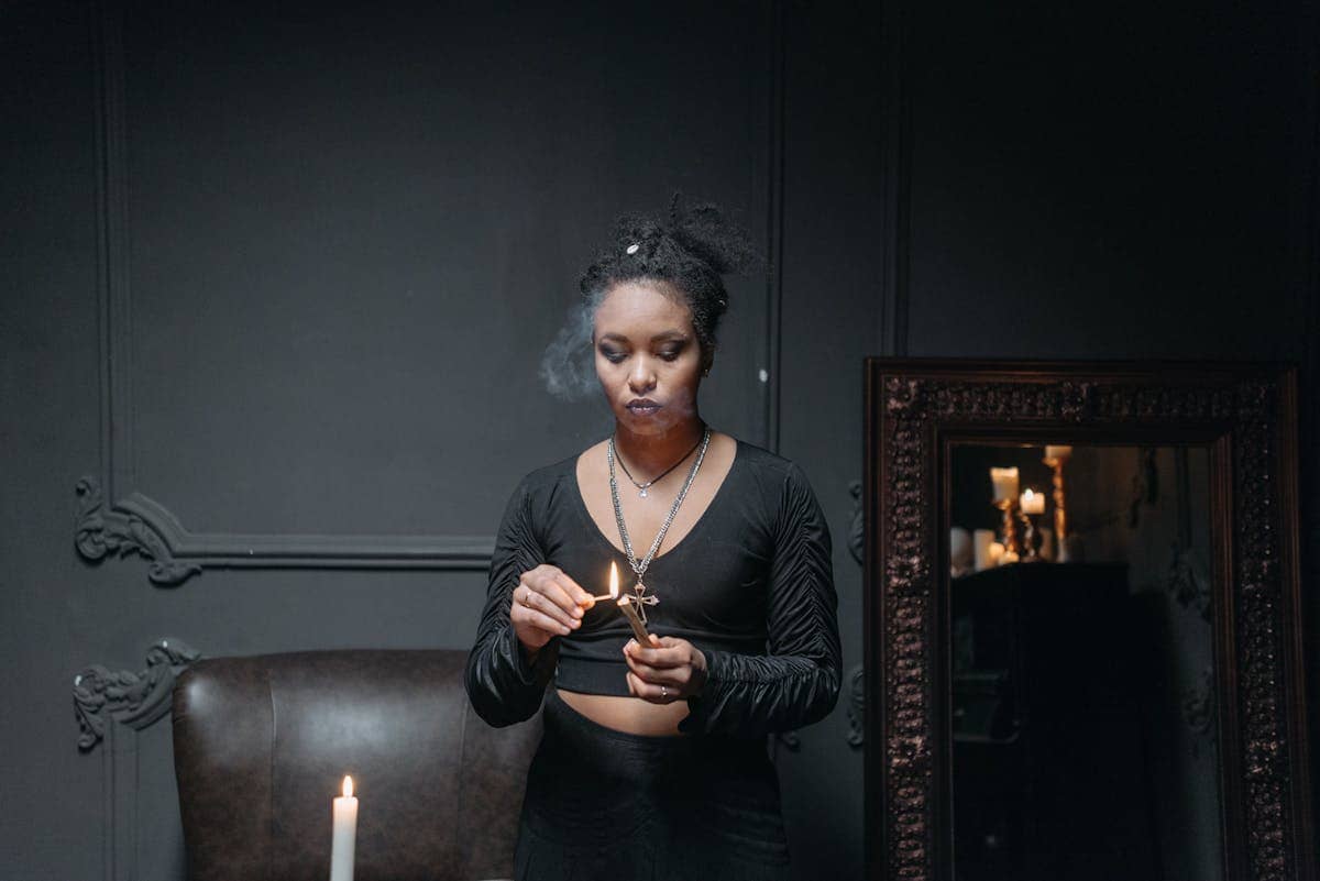 Woman in a mystical ritual scene lighting a match representing the deliberate preparation required for scrying practice