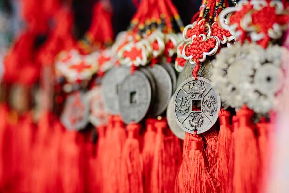 Collection of assorted Chinese feng shui coins with red satin threads symbolizing wealth and prosperity