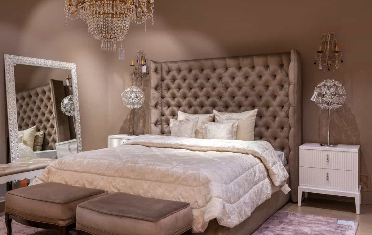 Bedroom with a framed mirror mounted on the wall beside the bed and nightstand showing correct mirror hanging height