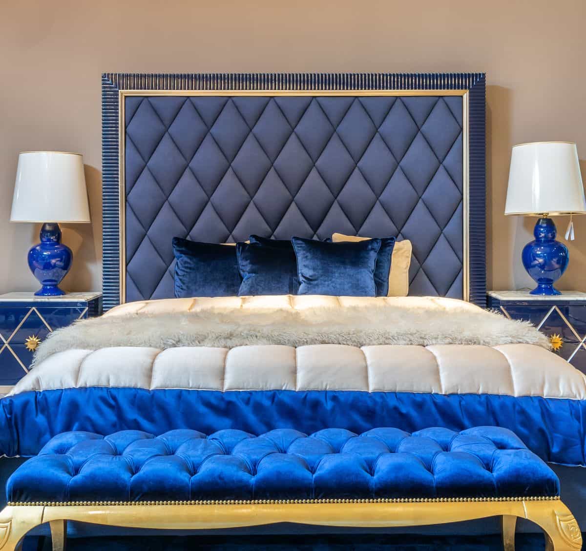 Bedroom with a bed and an upholstered bench acting as a buffer near the wall, illustrating a feng shui buffer cure