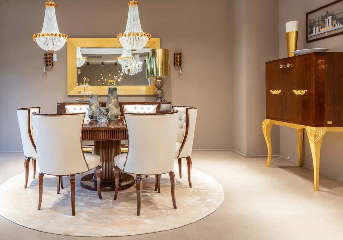 Console styling with a wall mirror illustrating round mirror decor in an entryway Round wooden table with vases near a wall mirror in a bright apartment, illustrating round mirror decor in an entryway