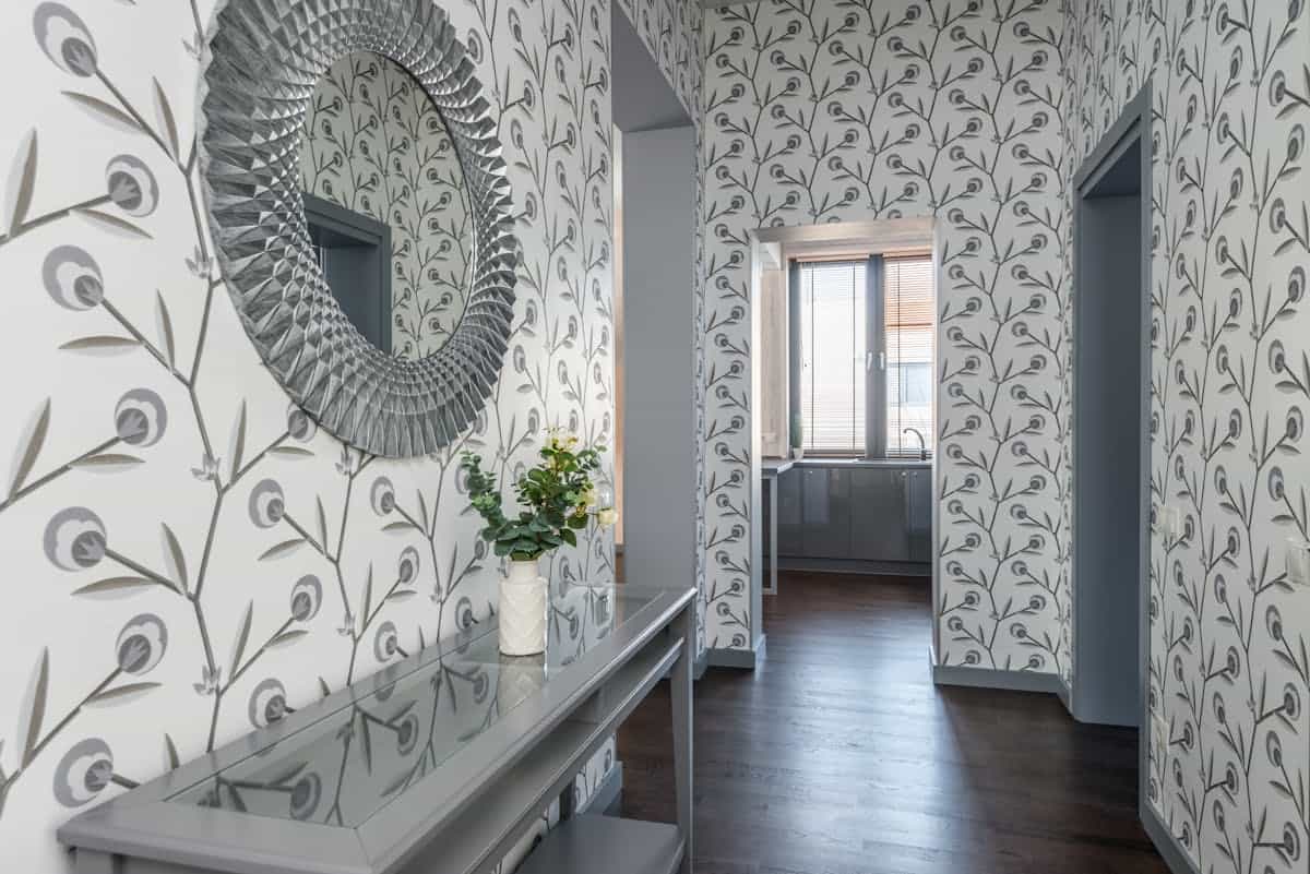 Contemporary hallway mirror reflecting light, showing what an entryway mirror should reflect Contemporary hallway with a mirror above a table reflecting light, showing what an entryway mirror should reflect