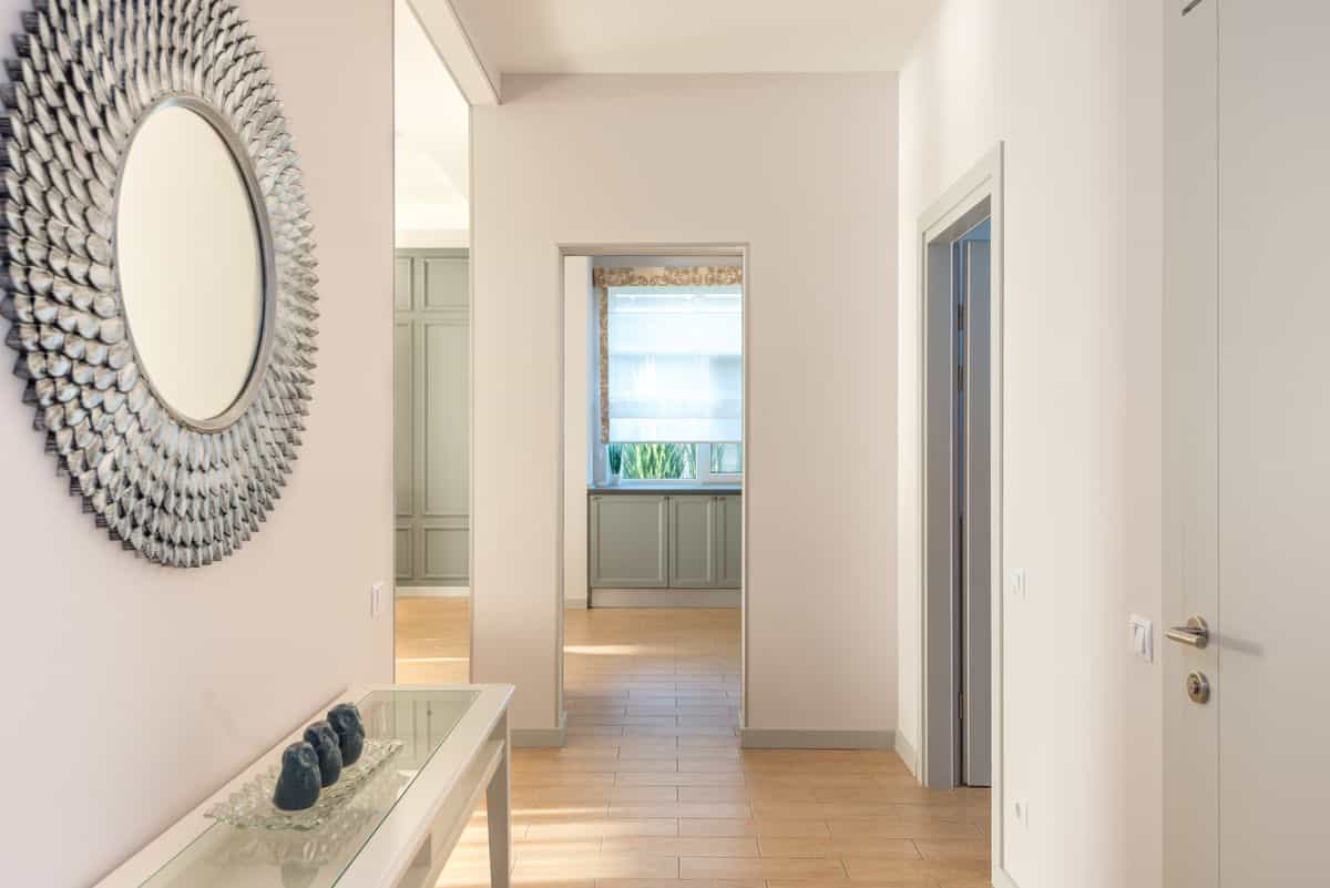 Bright minimalist hallway illustrating what hallway mirrors should reflect Minimalist hallway with wall art and natural light, showing what a hallway mirror should reflect