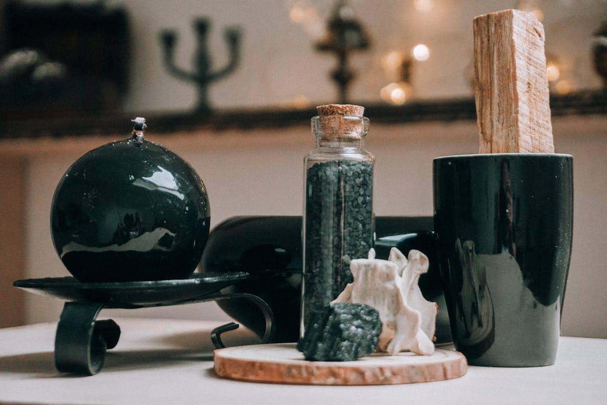 Black obsidian sphere and magic ritual items arranged on a wooden board for divination practice