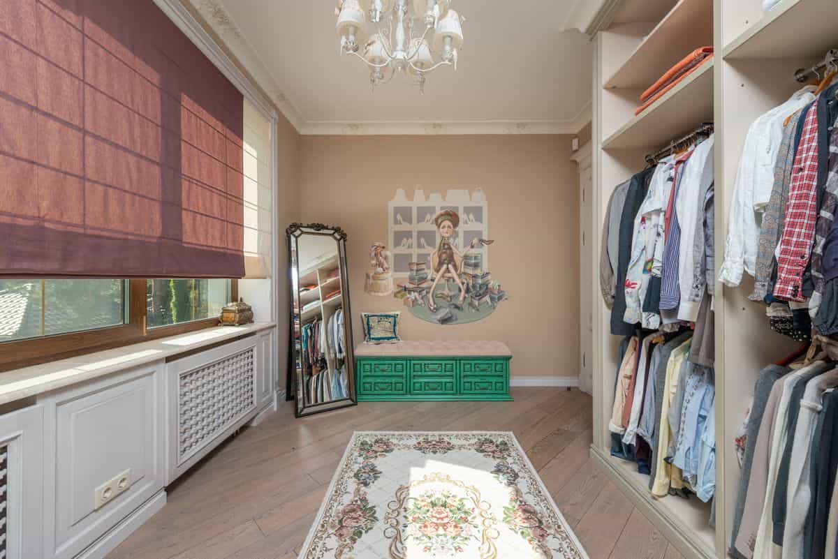 Walk-in wardrobe with a full-length mirror and chandelier showing full-length wardrobe mirror placement