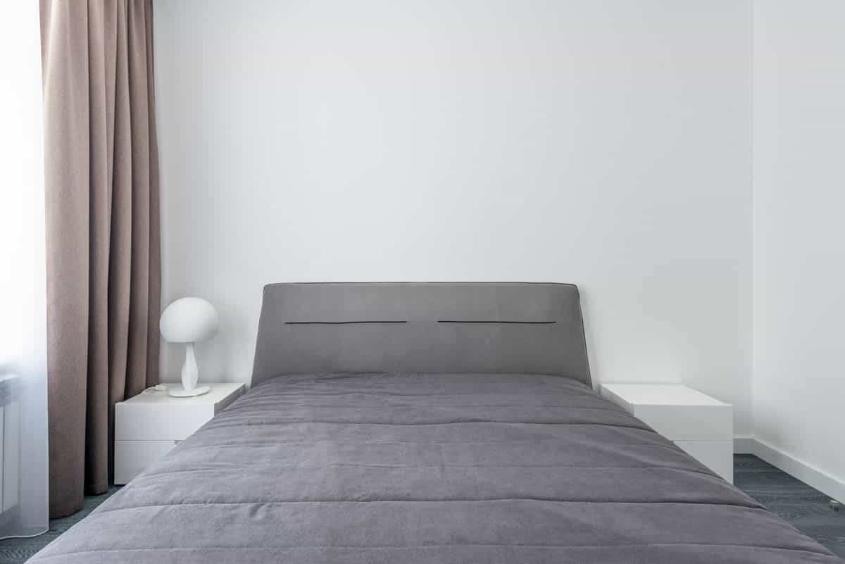 Serene minimalist bedroom with the bed placed to view the room, illustrating the feng shui commanding position