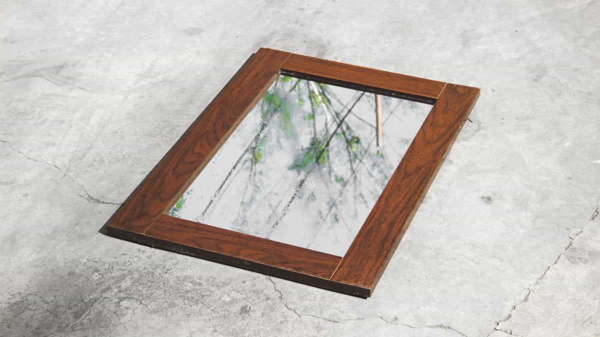 Wooden framed mirror reflecting an outdoor scene, illustrating how mirror glass quality affects reflection