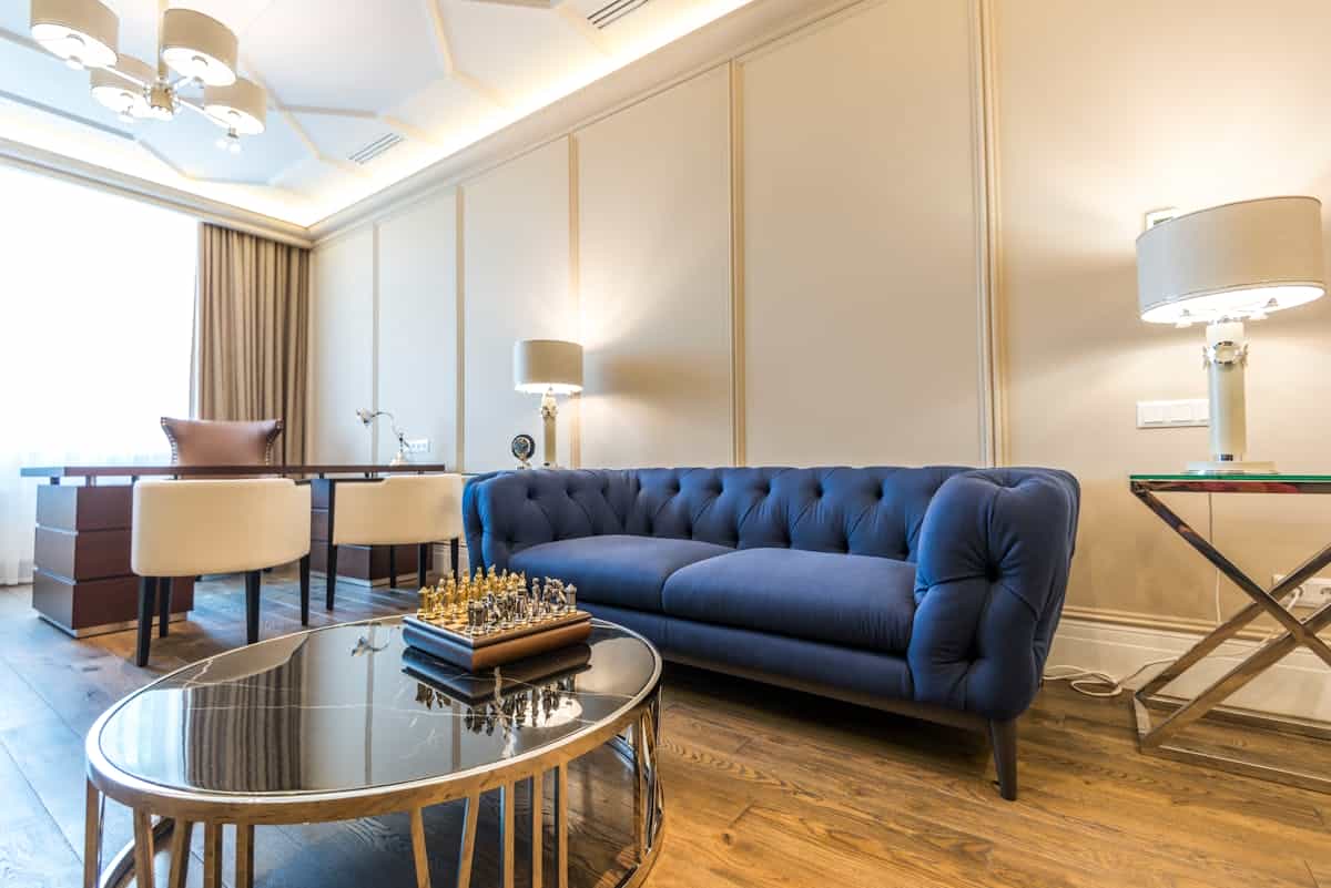 Living room with a blue couch illustrating calm Water and Metal feng shui colors Bright modern living room with a blue couch and natural light, illustrating the calming feng shui Water element