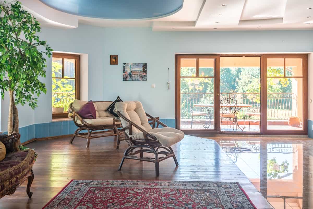 Spacious living room with sunlight from a balcony and balanced decor, illustrating feng shui five elements and lighting