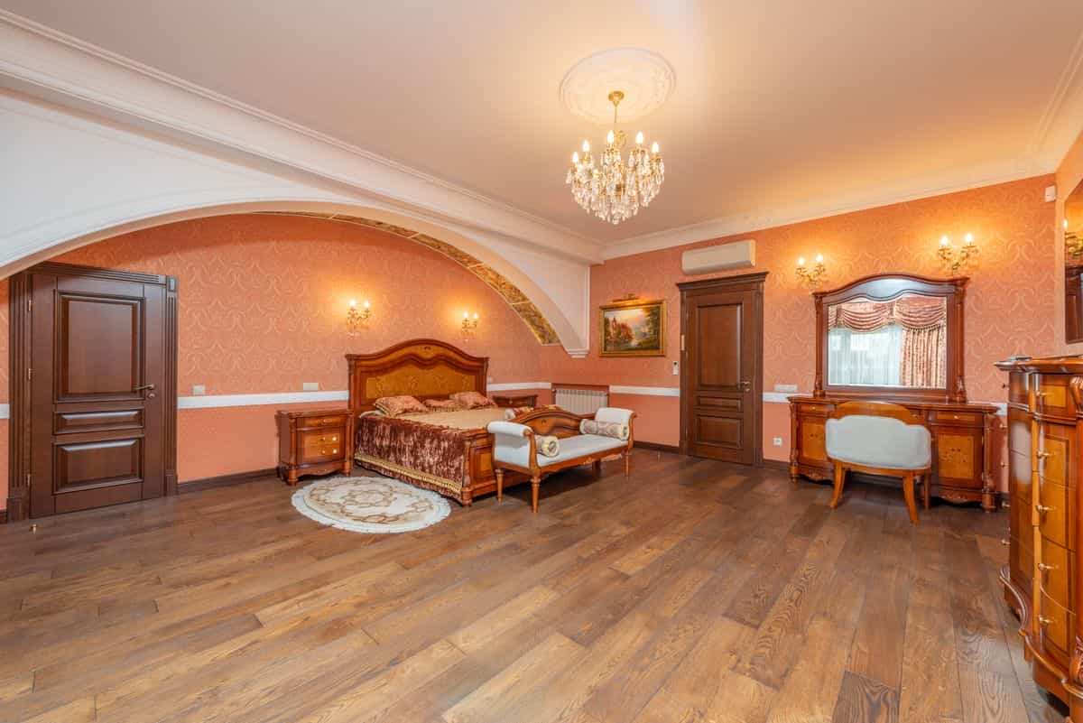 Classic bedroom with elegant furniture illustrating how to style an arched mirror in a bedroom Luxurious classic bedroom with vintage wooden furniture and chandelier lighting, illustrating arched mirror bedroom ideas