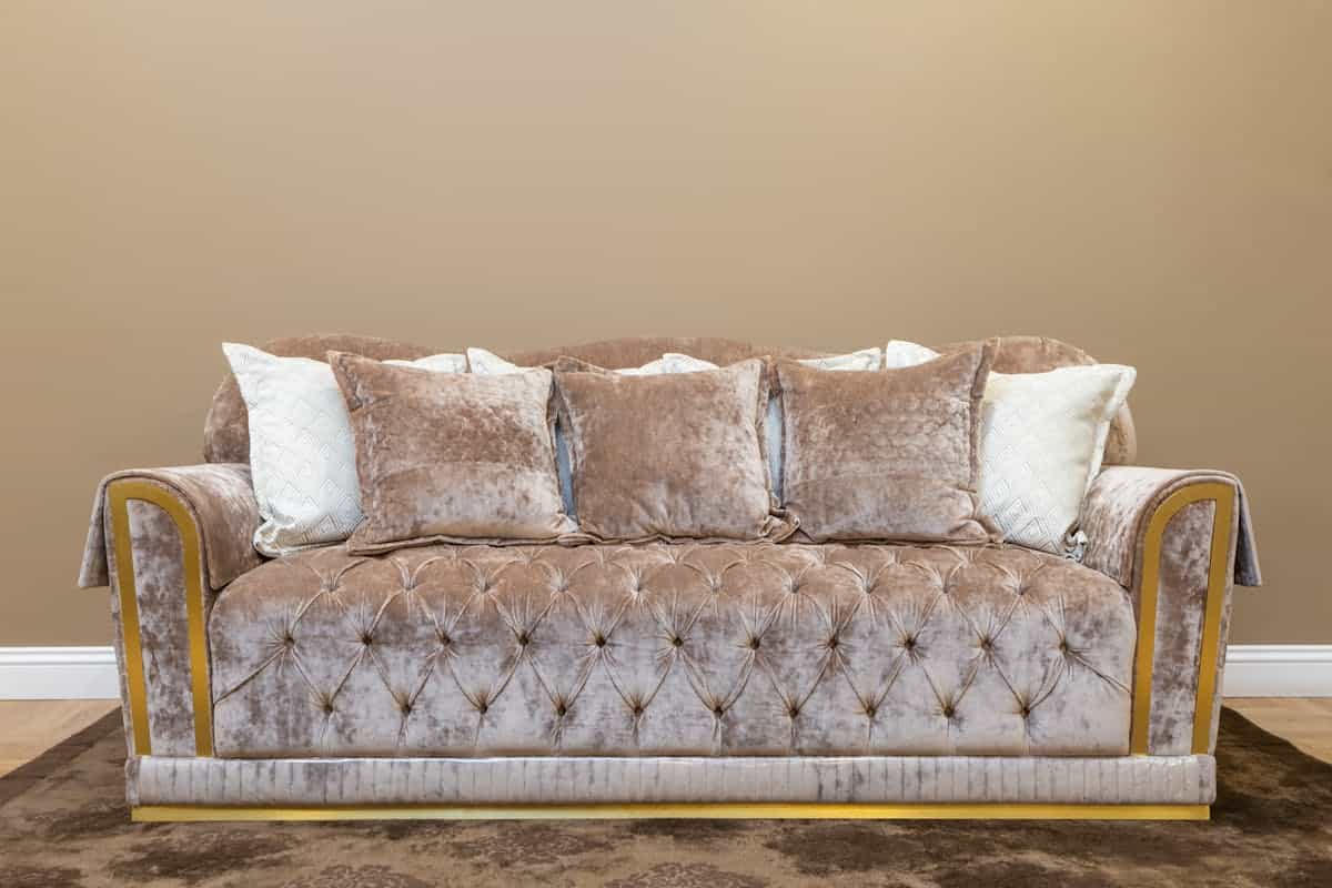 Beige sofa with cushions illustrating grounding feng shui sofa colour choices Beige sofa with plush cushions in a stylish, calm living room, illustrating feng shui sofa colour choices