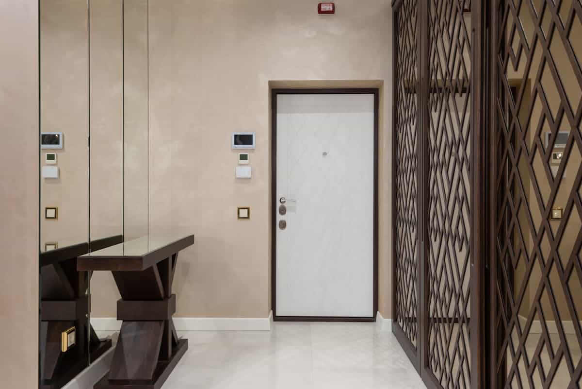Elegant hallway mirror and furniture illustrating a built entryway bench with mirror arrangement Elegant hallway with mirrors and modern furniture, showing a built entryway bench and mirror arrangement