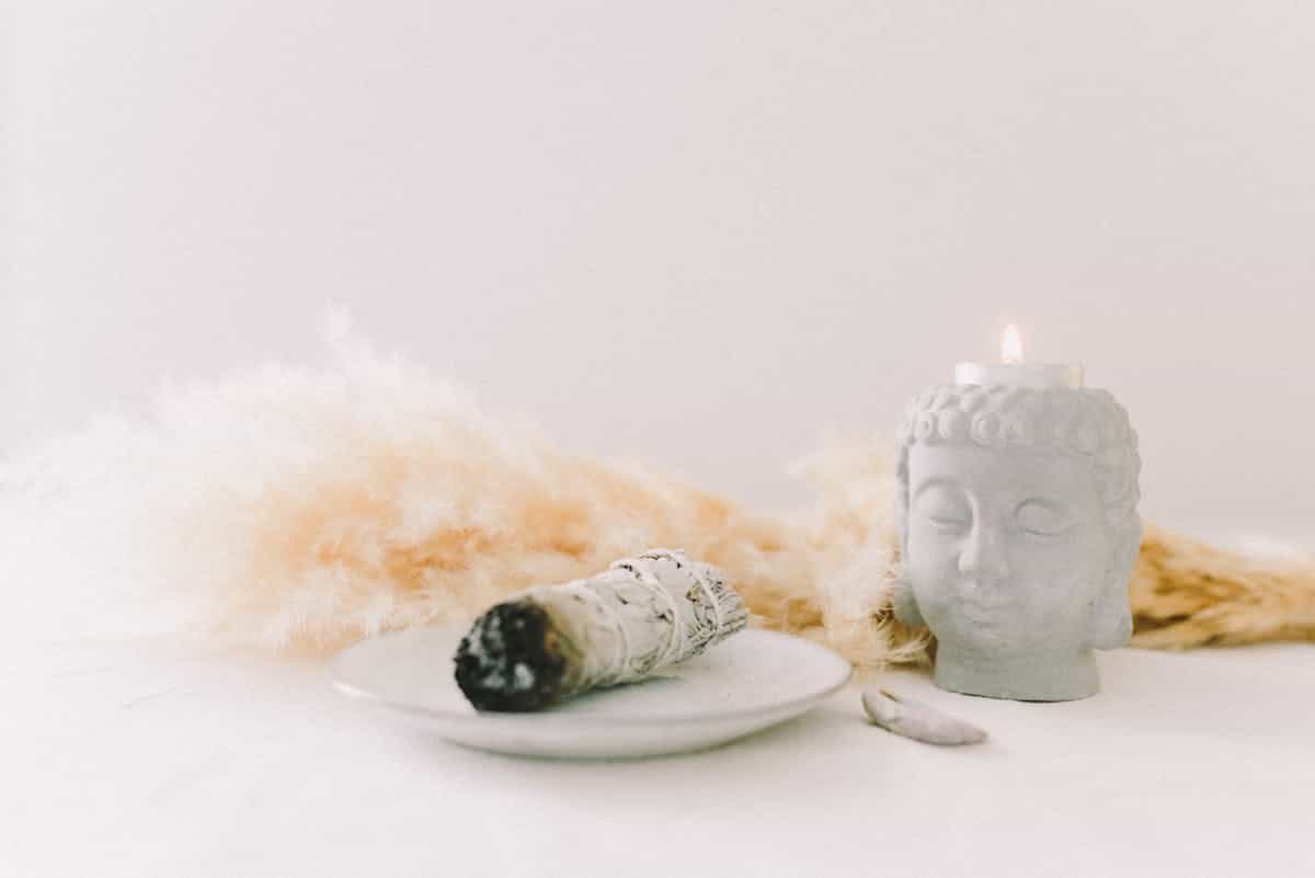 Sage cleansing bundle near ritual objects signalling intentional grounded transitions